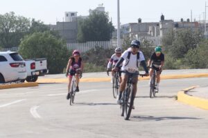 Atletas compitiendo en la prueba de ciclismo durante el evento inaugural en Villa de Tezontepec