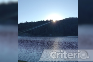 Al atardecer, el reflejo azul intenso de la presa crea un paisaje inolvidable, rodeado de montañas y vegetación exuberante