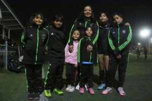La entrenadora compartiendo su experiencia con jóvenes futbolistas, inspirando a futuras generaciones con su historia de perseverancia y éxito.
