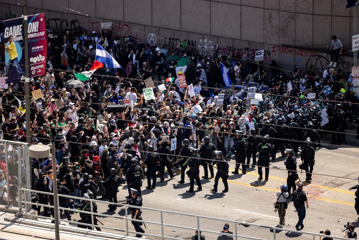 Agentes federales se enfrentaron con multitudes enfurecidas en un suburbio de Los Ángeles, mientras las protestas se extendían por segunda noche consecutiva el sábado, lanzando granadas aturdidoras y cerrando parte de una autopista en medio de las redadas contra migrantes indocumentados, según reportes. (Foto de ETIENNE LAURENT / AFP)