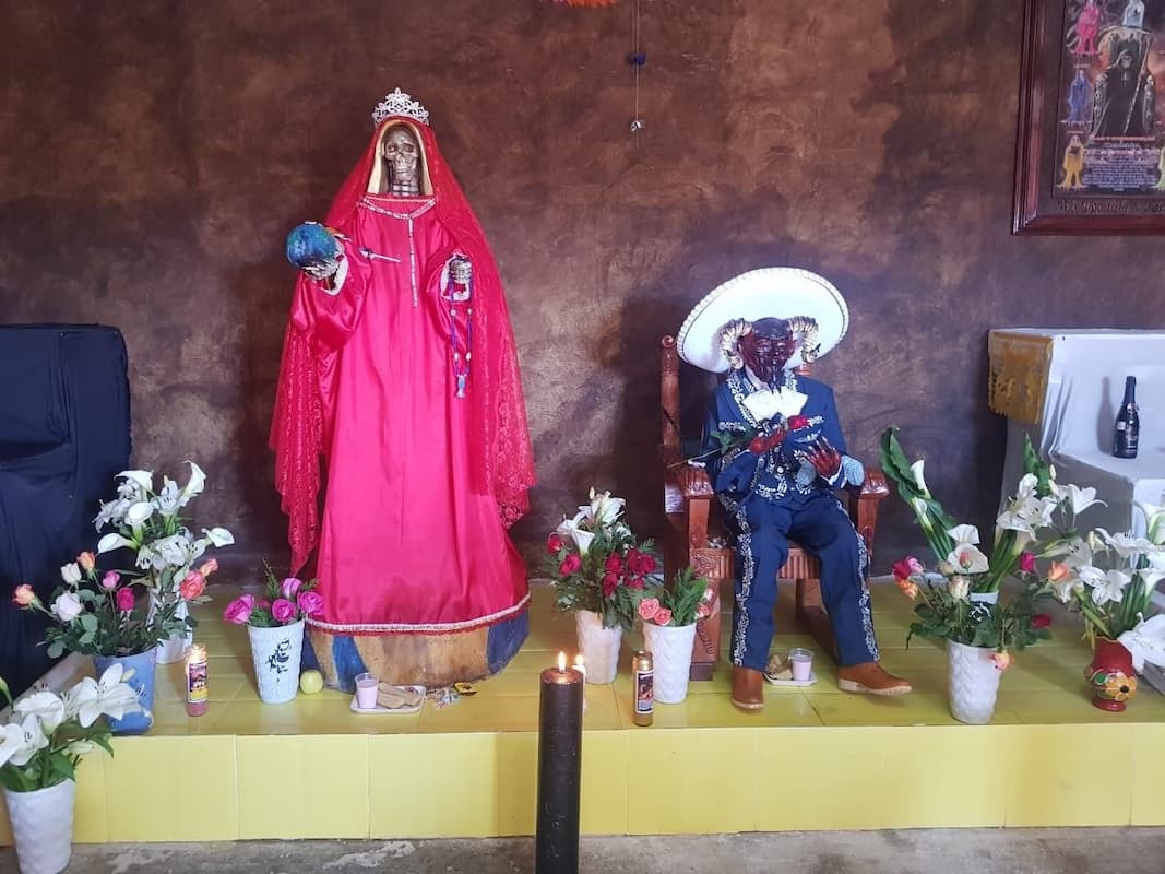  En el interior, se observan figuras de tamaño real de demonios vestidos con trajes de charro, mientras flores, veladoras, globos e incienso adornan el recinto / Foto de redes sociales 