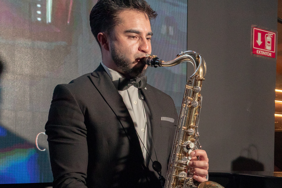 El saxofonista, con un toque de elegancia y talento, acompaña la presentación de la Cadillac Optiq, fusionando el lujo con la música en una noche única en Pachuca. | Fotografías: Misael Salinas