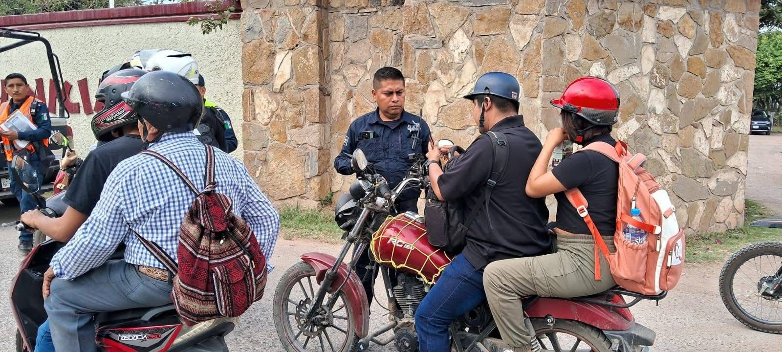 Personal de la Dirección de Tránsito y Vialidad de Huejutla entregando trípticos a motociclistas