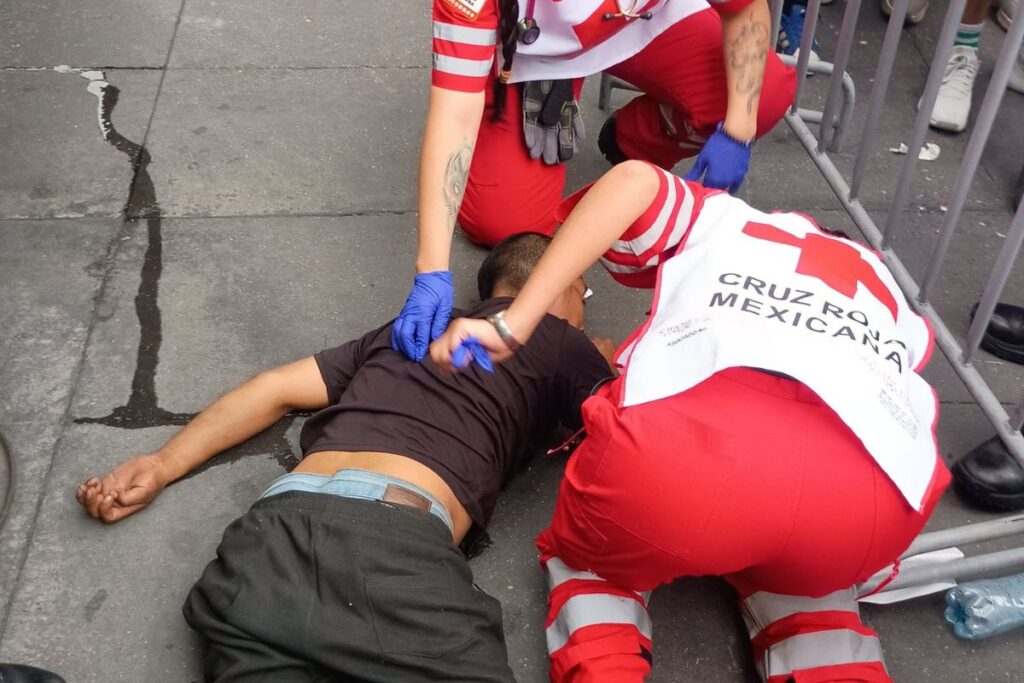 Paramédicos de la Cruz Roja atienden a hombre inconsciente tras sufrir un accidente en el Zócalo de la Ciudad de México