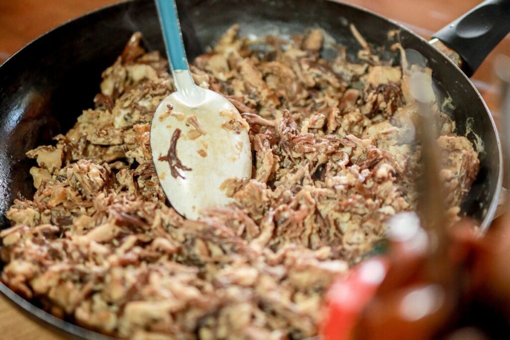 Detalle de una sartén preparando hongos salteados